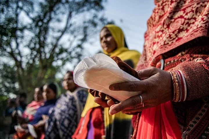 A sanitary pad being handed directly to a woman as part of a hygiene access initiative